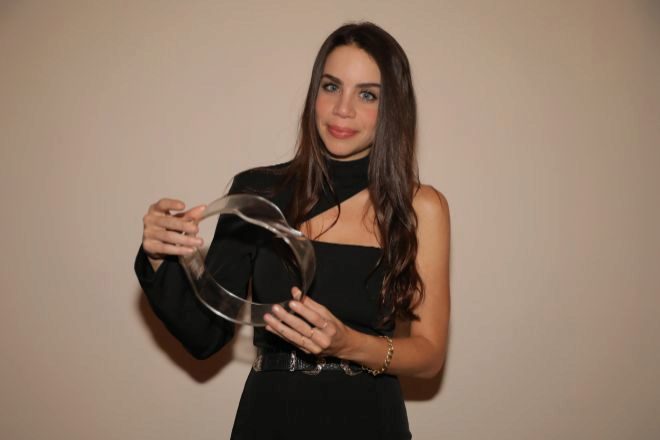 La artista Carla Cacales con uno de los trofeos que diseñó para los ganadores.
