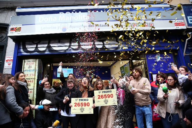 Un grupo de personas celebran en una administración de Lotería de Madrid el Gordo de Navidad de 2019.