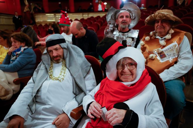 Varias personas disfrazadas esperan el comienzo del sorteo de El Gordo de Navidad en el Teatro Real en Madrid.