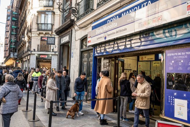 Largas colas a las puertas de la administración de lotería de Doña Manolita este jueves en Madrid, en la víspera de celebración del Sorteo de "El Niño".