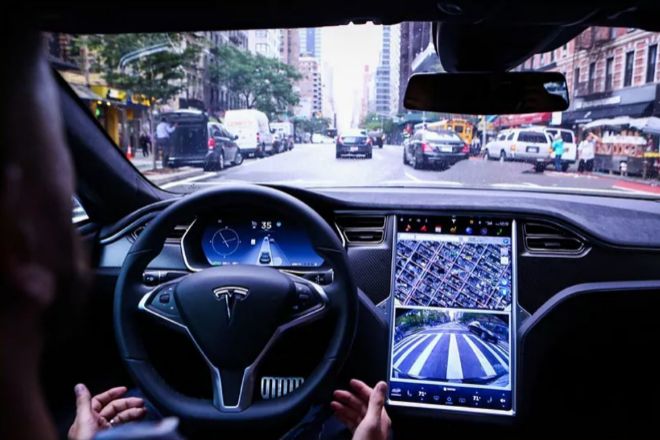 Un conductor levanta las manos del volante en un Tesla.