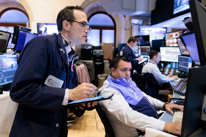 Operadores de Bolsa en Wall Street analizando los últimos datos económicos en sus pantallas.