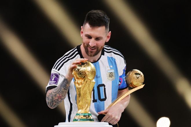Leo Messi acaricia la copa del mundo tras ganar la final del mundial de Qatar.