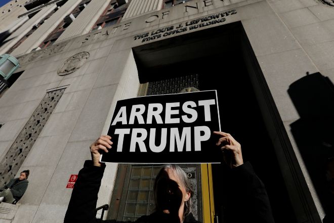 Una activista reclama el arresto de Donald Trump ante el tribunal penal de Manhattan.