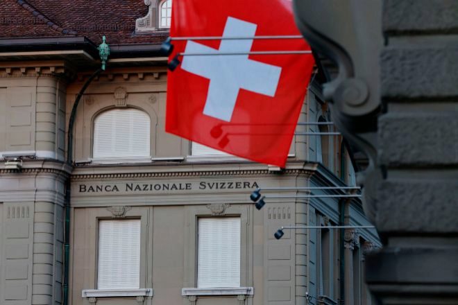 Una bandera nacional suiza frente a la sede del Banco Nacional Suizo (BNS).