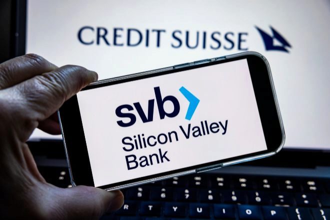 Logo de Silicon Valley Bank en un móvil y de Credit Suisse en un portátil.