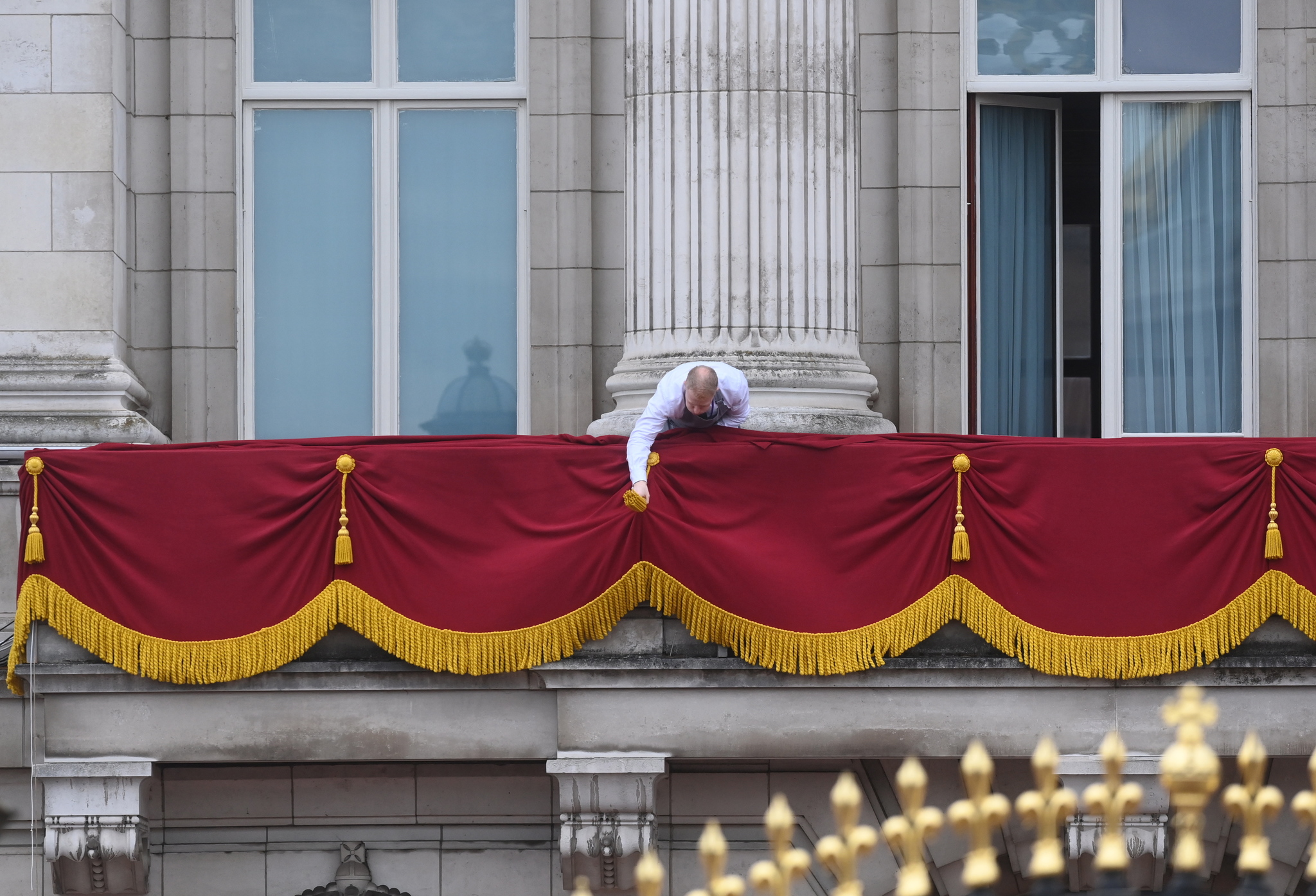 El personal del Palacio de Buckingham ha preparado con mimo todos los detalles para que la coronación sea perfecta. En la imagen, un empleado engalana el balcón desde el que saludará la Familia Real.
