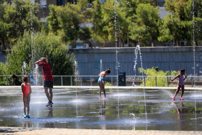 Gente refrescándose en la zona de Madrid Río este lunes para combatir la ola de calor.
