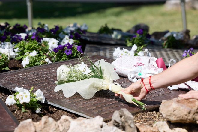 Varias personas depositan flores durante el acto de homenaje por el 15º aniversario de la tragedia de Spanair.