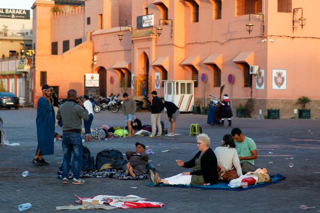 Varias personas descansan en medio de una calle de Marrakech a primera hora de este sábado.