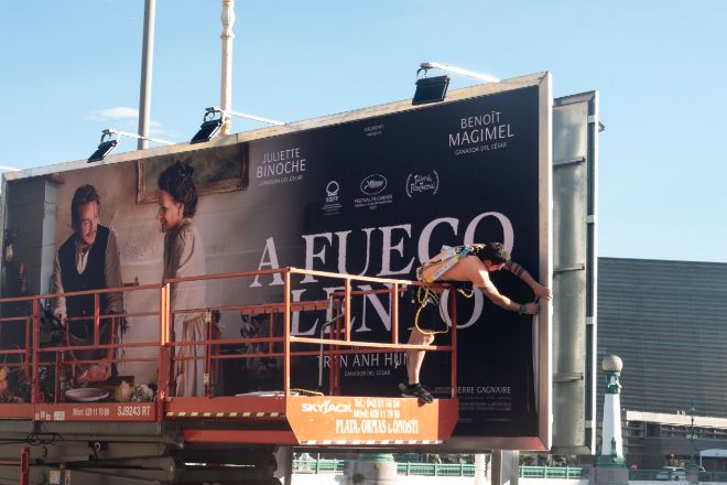 Un operario coloca los carteles de la 71.ª edición de Festival  Internacional de Cine de  San Sebastián, que arranca el sábado.