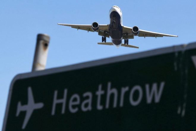 Un avión sobrevuela un cartel mientras se prepara para aterrizar en el aeropuerto de Heathrow.