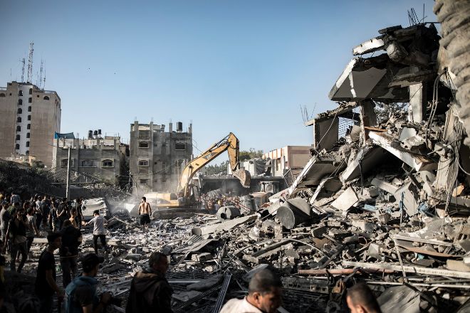 Palestinos buscan supervivientes entre los escombros de un edificio residencial en Khan Younis, al sur de Gaza.