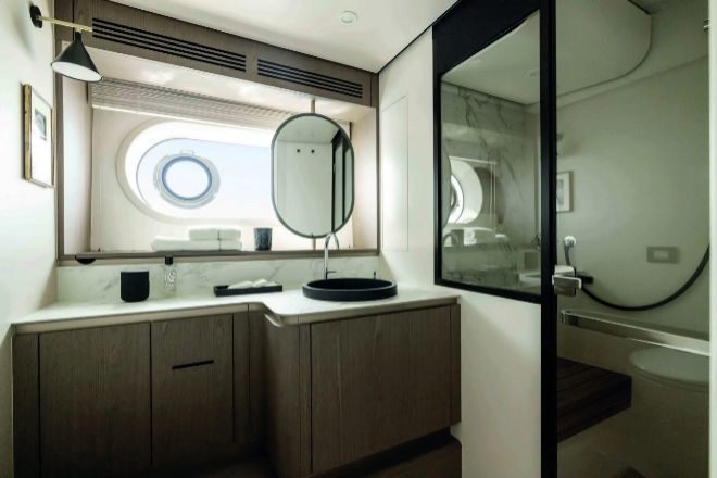 En el baño domina un gran espejo  con acabados de teca en el box de la ducha; la grifería es de Hansgrohe.