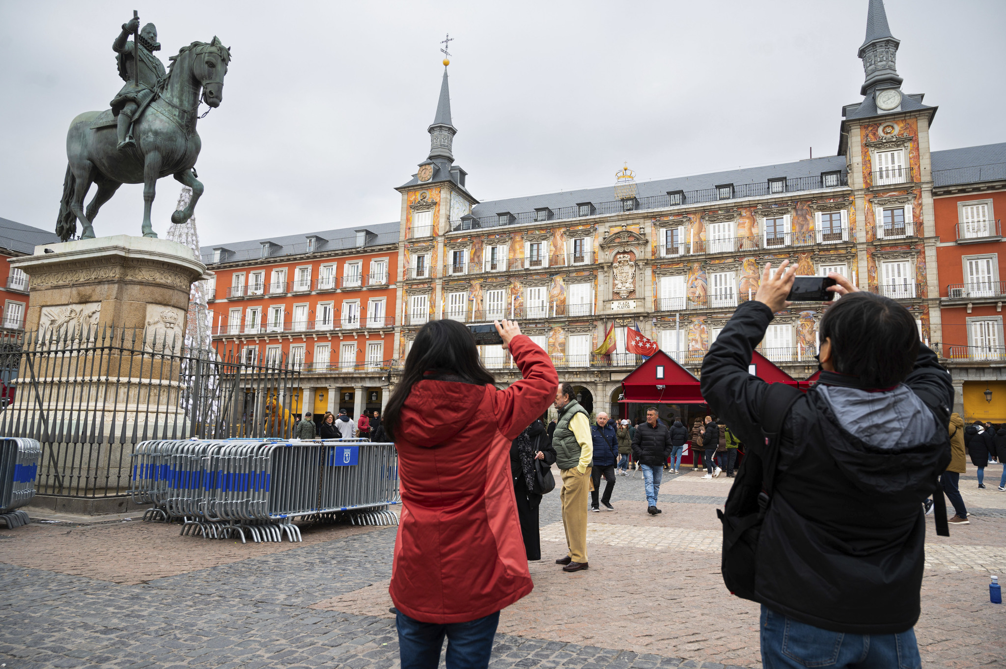 Unos turistas hacen fotografías en la plaza Mayor de  Madrid.