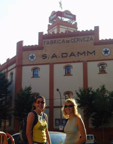 Dos turistas posan junto a la fbrica de cerveza de 'Estrella Damm' en Barcelona