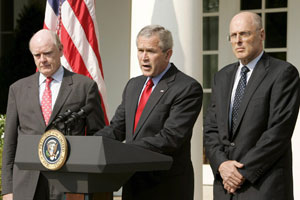 John Snow (izq.), en el anuncio de su relevo como secretario del Tesoro por Henry Paulson (der.), en mayo de 2006. En el centro, G.W. Bush | Foto EFE