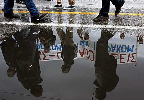 Reflejo en un charco de unos manifestantes en una protesta convocada en el centro de Atenas el 5 de junio de 2010 en contra de las reformas de la seguridad social y el sistema de pensiones impuestas por el Gobierno griego. EFE/Simela Pantzar